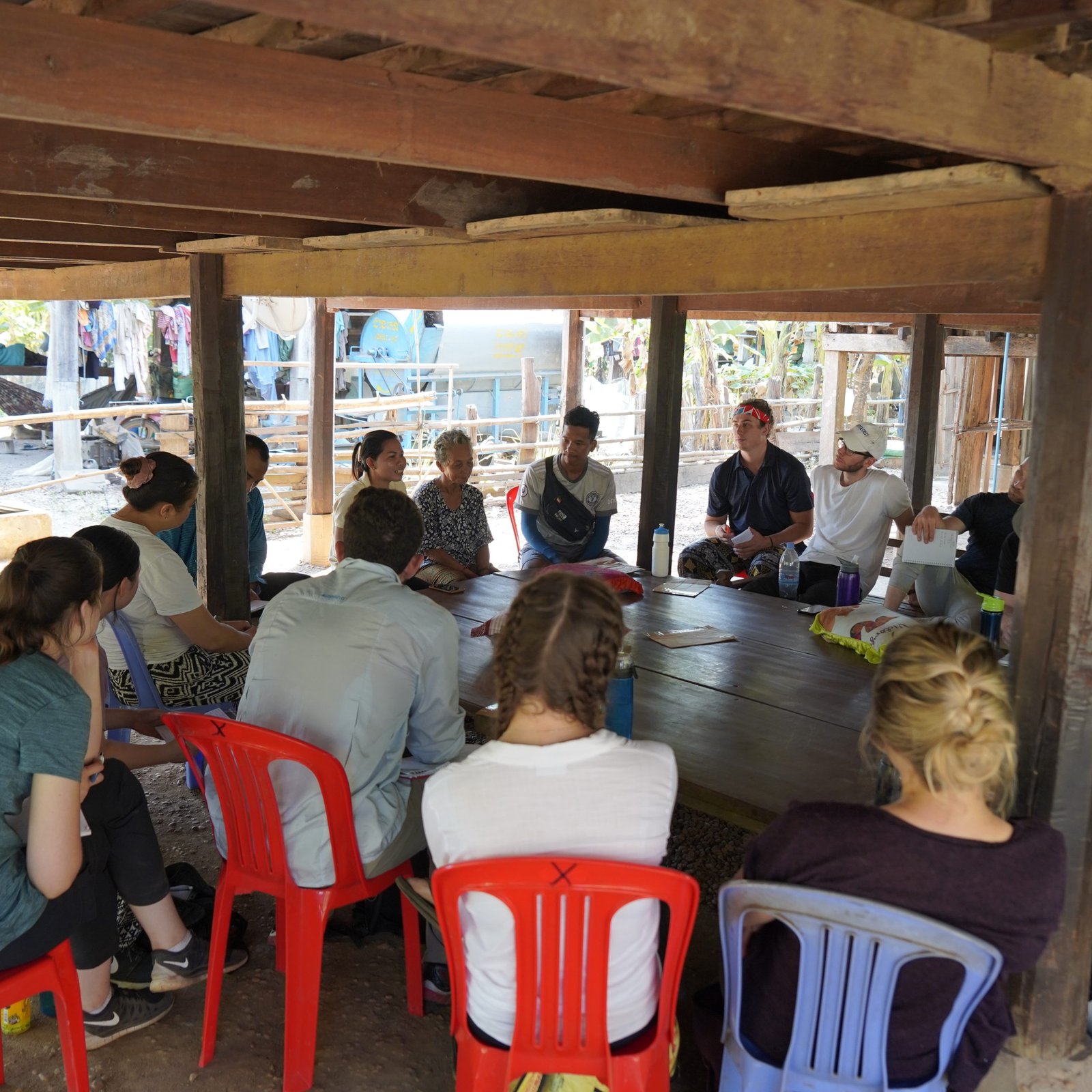 Tourists Learning Village History Beneath a Khmer Traditional Wooden House